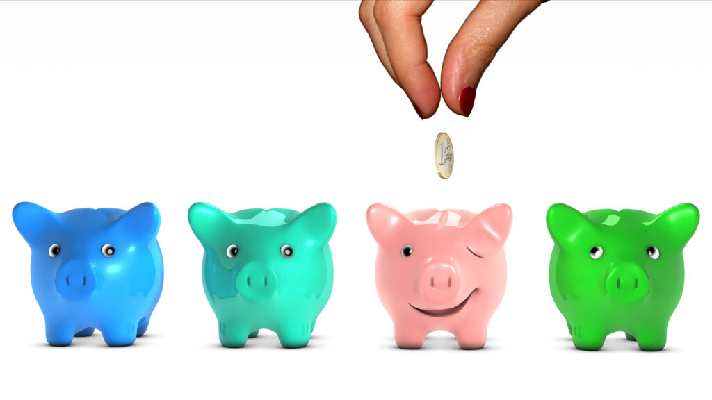 woman's hand choosing a piggy bank and giving it a piece of mone